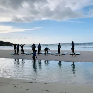 A group of people on the beach with surf boards