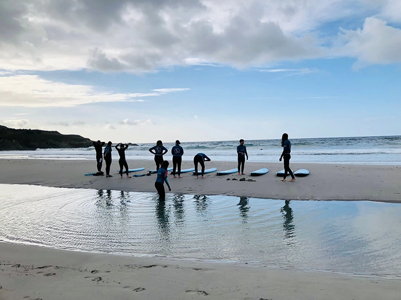 A group of people on the beach with surf boards