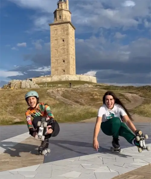Two skaters in front of a tower